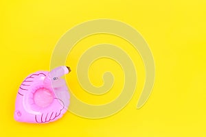 Summer beach composition. Simply minimal design with pink Inflatable flamingo isolated on yellow background. Pool float party,