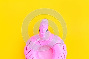 Summer beach composition. Simply minimal design with pink Inflatable flamingo isolated on yellow background. Pool float party,