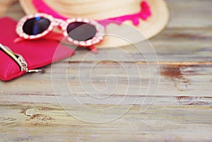 Summer Beach Holliday Concept. Straw Female Hat and Sunglasses on a light Wooden background. Selective focus. Copy Space.