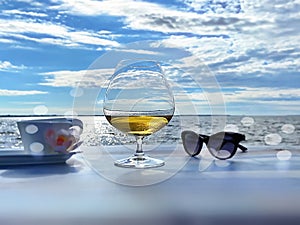 Summer beach sea landscape ,glass of juice sunglasses and cup of coffee on table top at beach cafe on front sea and sky white clou