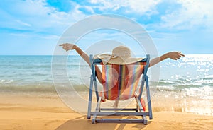 Summer beach vacation concept, Asia woman with hat relaxing and arm up on chair beach at Koh Mak, Trad, Thailand