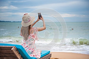 Summer beach vacation holidays trip concept, Happy young Asian woman with hat relaxing and taking a photo and selfie