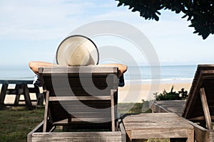 summer beach vacation young woman with hat relaxing on chair near sea and sky background