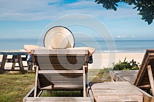 summer beach vacation young woman with hat relaxing on chair near sea and sky background