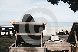 summer beach vacation young woman with hat relaxing on chair near sea and sky background