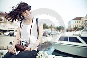 Summer beach woman fun holding vintage retro camera laughing and smiling happy during summer holiday vacation travel