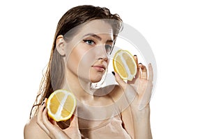 Summer. Beautiful young woman with lemon slice over white background. Cosmetics and makeup, natural and eco treatment