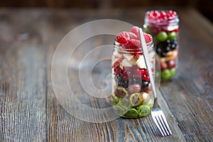 Summer berries smoothie in mason jar on rustic wooden table