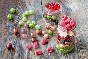 Summer berries smoothie in mason jar on rustic wooden table