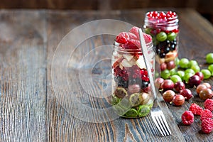 Summer berries smoothie in mason jar on rustic wooden table