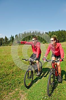 Summer bike - Young sportive couple in meadow