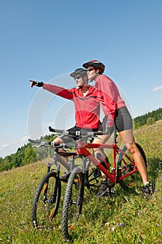 Summer bike - Young sportive couple in meadow