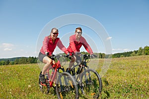 Summer bike - Young sportive couple in meadow photo