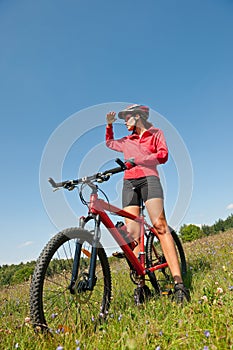 Summer bike - Young sportive woman in meadow
