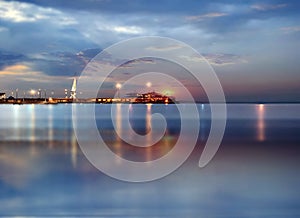 Summer blue  night in harbor port of Tallinn blurred city  light on promenade and on horizon cruise ship foggy weather on sea wat