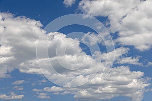 Summer blue sky of various shades and white fluffy light cumulus clouds floating in height