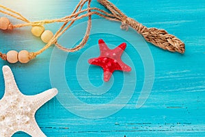 Summer board of sea shells scallop and star fish on blue wooden background