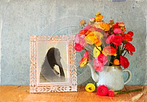 Summer bouquet of flowers and victorian frame with vintage portrait of young woman on the wooden table. image with textured overl