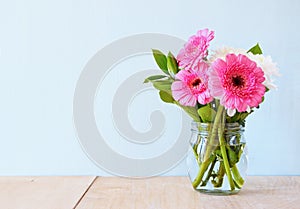 Summer bouquet of flowers on the wooden table with mint background. vintage filtered image photo
