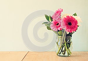 Summer bouquet of flowers on the wooden table with mint background. vintage filtered image