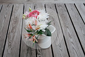 Summer bouquet of garden flowers on a rustic table at country cottage