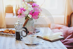 summer breakfast in cozy country house. Table with bouquet of flowers from own garden, french press with coffee and cookies.