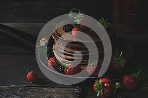 Summer breakfast with pancakes, strawberries, blackberries on old wooden table