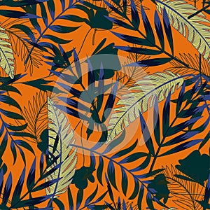 Summer bright original seamless pattern with tropical leaves and plants on an orange background. Vector design. Jung print. Floral