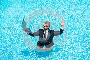 Summer business dreams. successful man. Businessman in suit with laptop in swimming pool. business man on summer