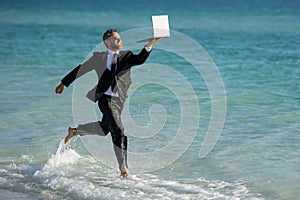 Summer business. Freelancer run on summer sea beach. Businessman in wet suit jump in sea water. Crazy business summer
