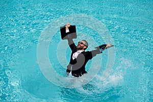 Summer business in swimming pool. Business man in suit and laptop splash water in swimming pool. Crazy summer business