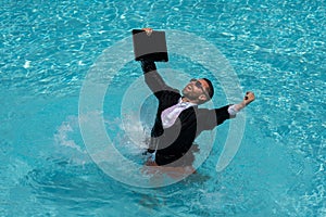 Summer business in swimming pool. Business man in suit and laptop splash water in swimming pool. Crazy summer business