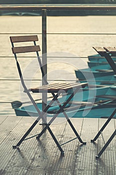 summer cafe chair on the pier of the city lake after the rain