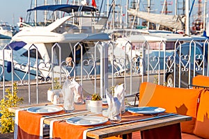 Summer cafe by the sea on a sunny day with a view of the yachts and palm trees