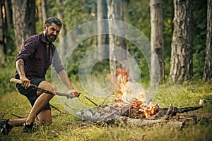 Summer campfire. Man hiker make fire in forest