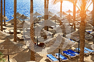 Summer chaise lounges under an umbrella on sandy sea beach in hotel Egypt, Sharm el Sheikh, concept time to travel