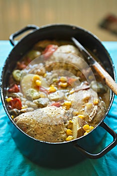 Summer chicken one pot with vegetables: potatoes, tomatoes, corn, broad beans