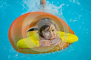 Summer child boy relax at aquapark. Summertime vacation. Summertime vacation. Kid with inflatable ring in swimming pool