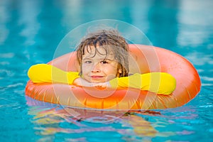 Summer child boy relax at aquapark. Summertime vacation. Summertime vacation. Kid with inflatable ring in swimming pool