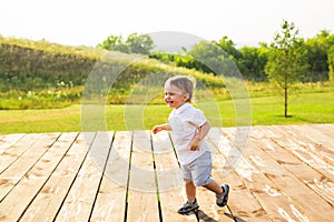 Summer, childhood and baby concept - little boy having fun in summer nature.