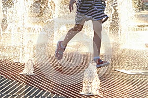 Summer in the city - children playing with fountain