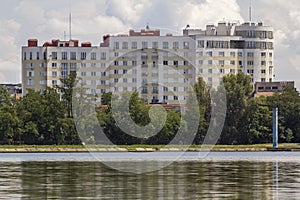 Modern residential apartment building among green trees. Property in ecological quiet area concept.