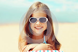 Summer close-up portrait smiling child little girl lying on beach