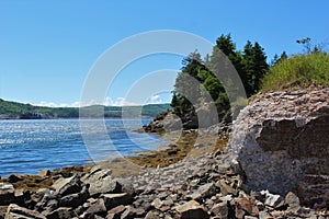 A summer coastal scene from Nova Scotia with a crumbling foundation on the Strait of Canso near the causeway