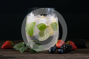 Summer  cocktail bmojito with rum, green mint, lime and crushed ice and  berries photo