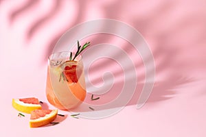 Summer cocktail with grapefruit, rosemary, and ice