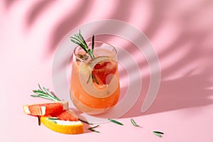 Summer cocktail with grapefruit, rosemary, and ice