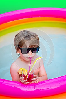 Summer cocktail. Vacation. Summer holidays. The child drinks colorful cocktail in sunglasses. Enjoyment Resort. Cocktail