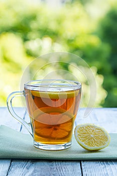 Summer cold cup of tea on a wooden table