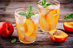 Summer cold drinks: homemade peach lemonade with ice cubes, and mint in glasses